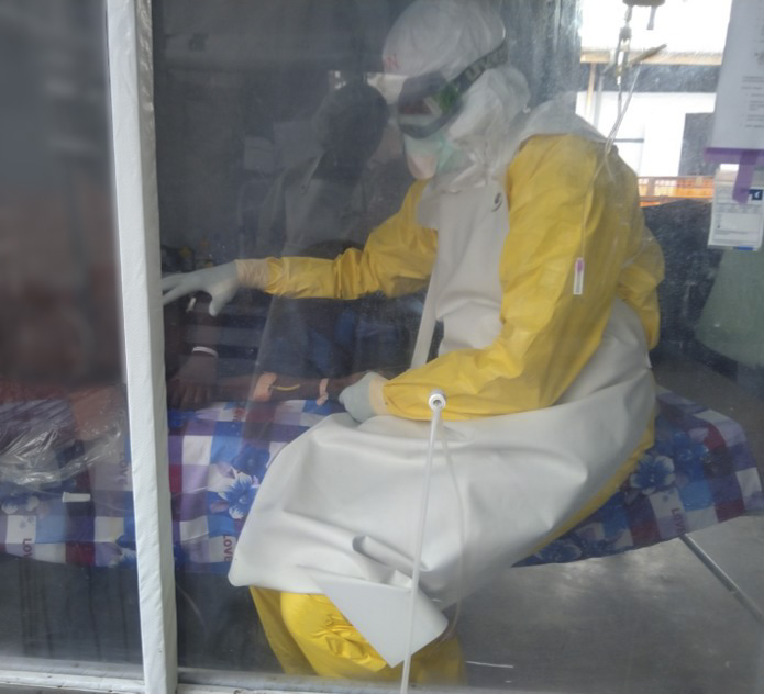 Ian Crozier, M.D., Frederick National Laboratory/NIAID, administers supportive care and an experimental treatment to a patient in one of the Ebola treatment units. 